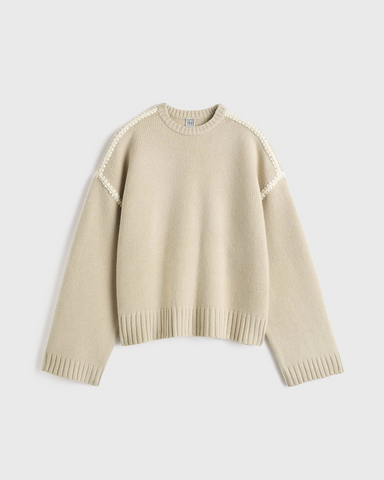 Beige sweater med ribkant og broderi på skuldre og ærmegab. Crew-halsudskæring.