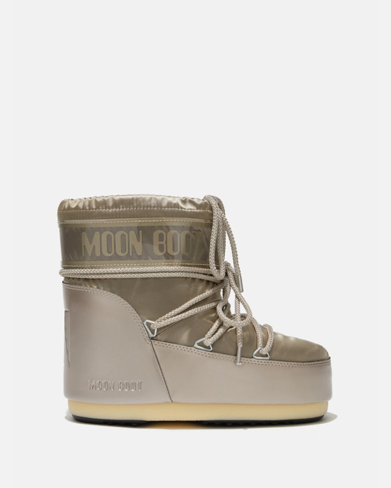 Skinnende platinstøvle med Moon Boot-logo, krydsede snørebånd og kraftig sål.